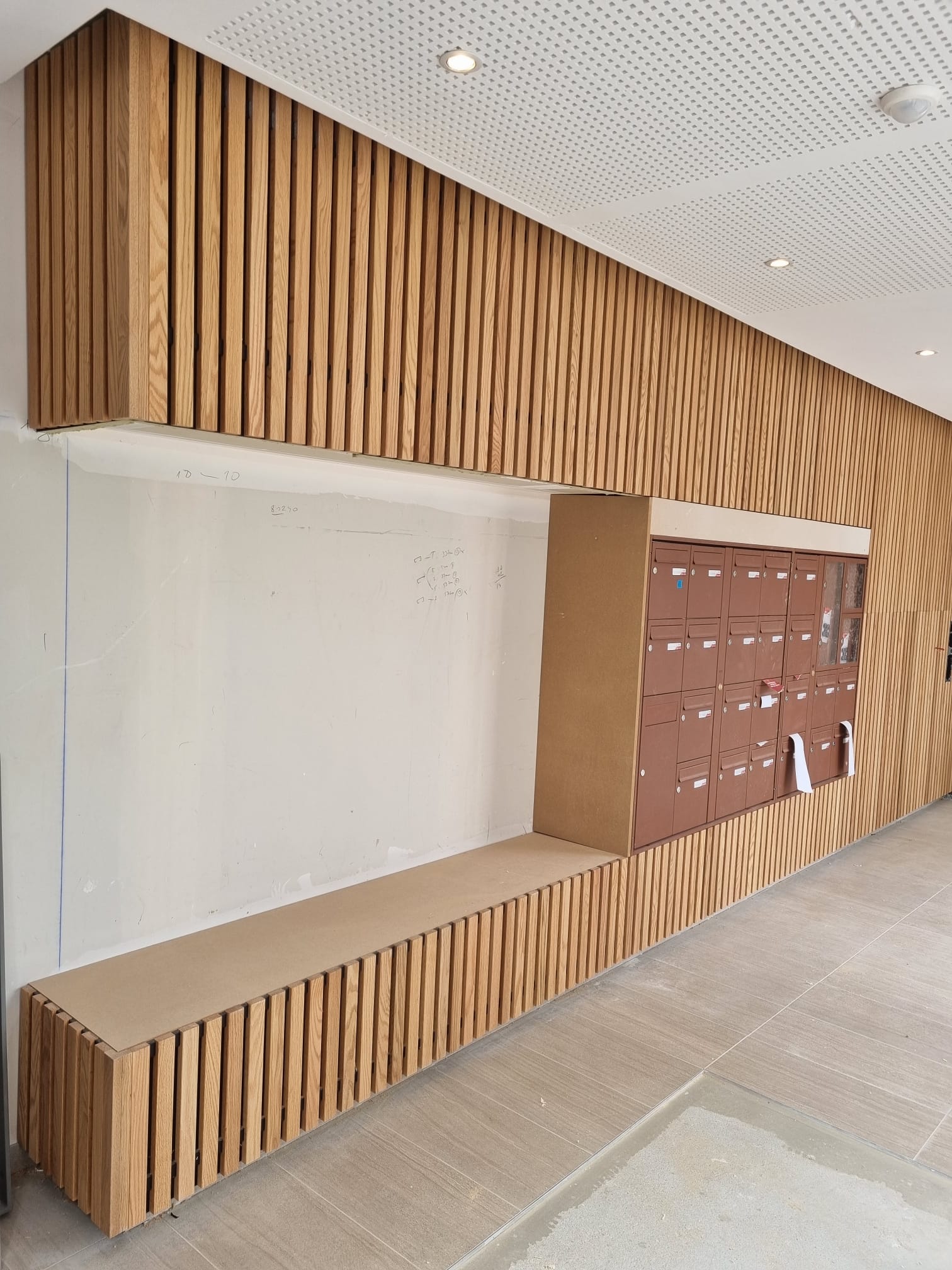 Hall d'entrée avec habillage à clins et boîtes aux lettres